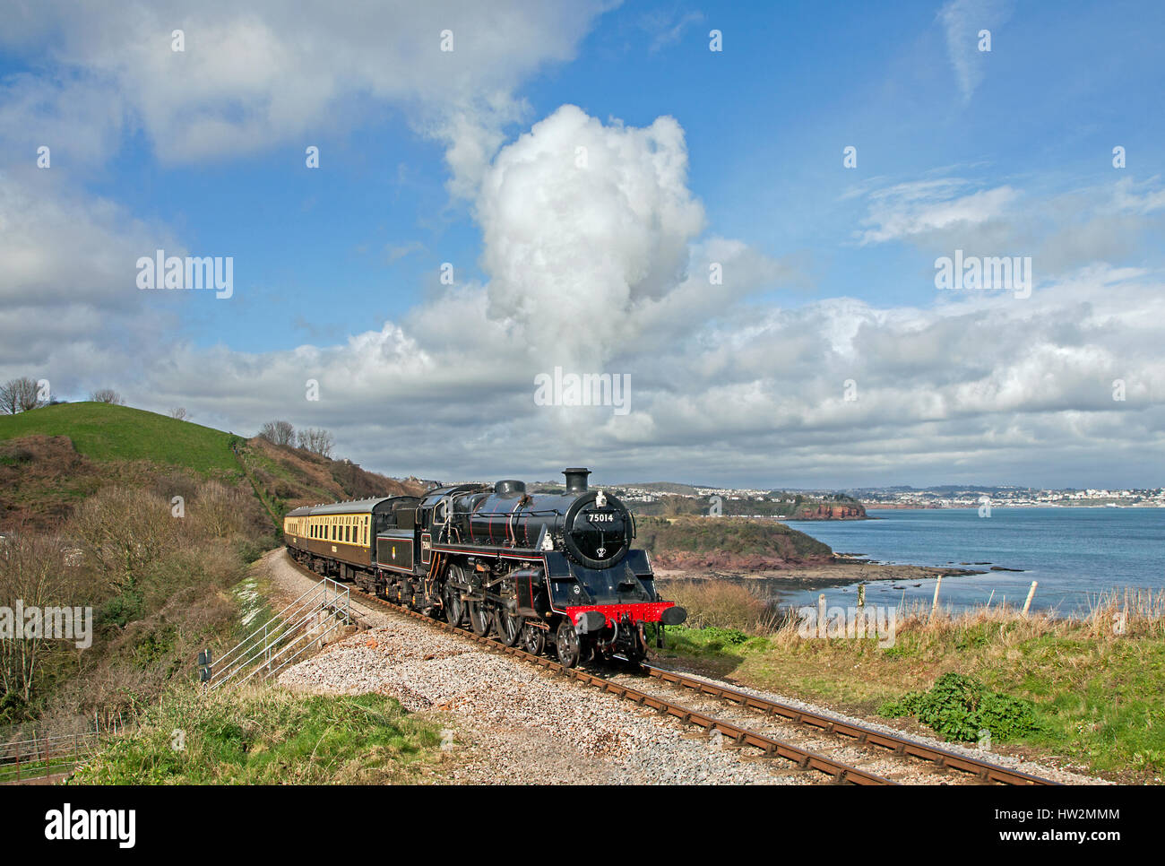 75014 passes 'Waterside' with Tor Bay in the background in Devon during a Timeline photo charter on 12 March 2017. The loco is about to start its firs Stock Photo