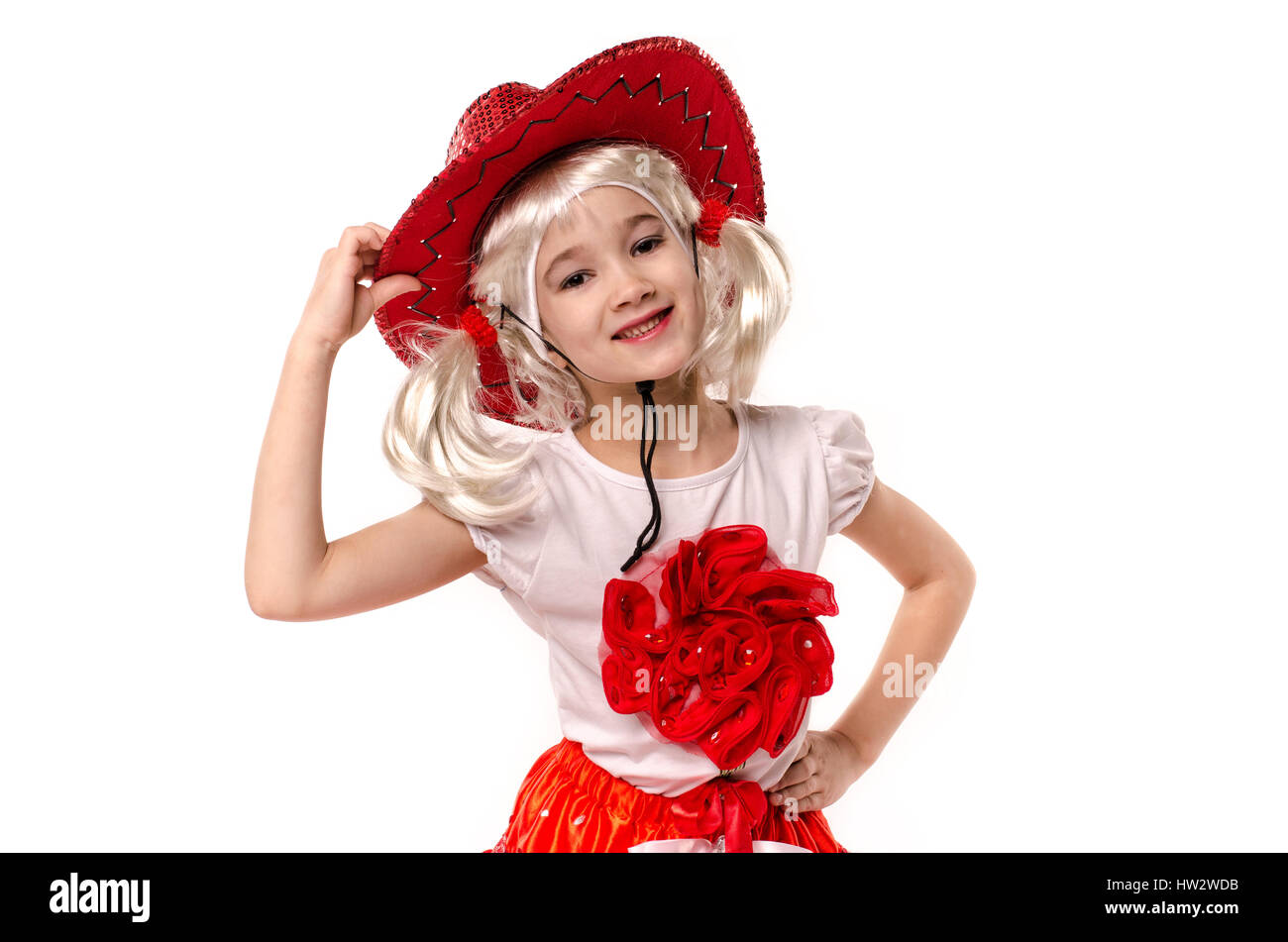 Cute little caucasian girl wearing red skirt, t-shirt with flowers and cowboy hat isolated on white background Stock Photo