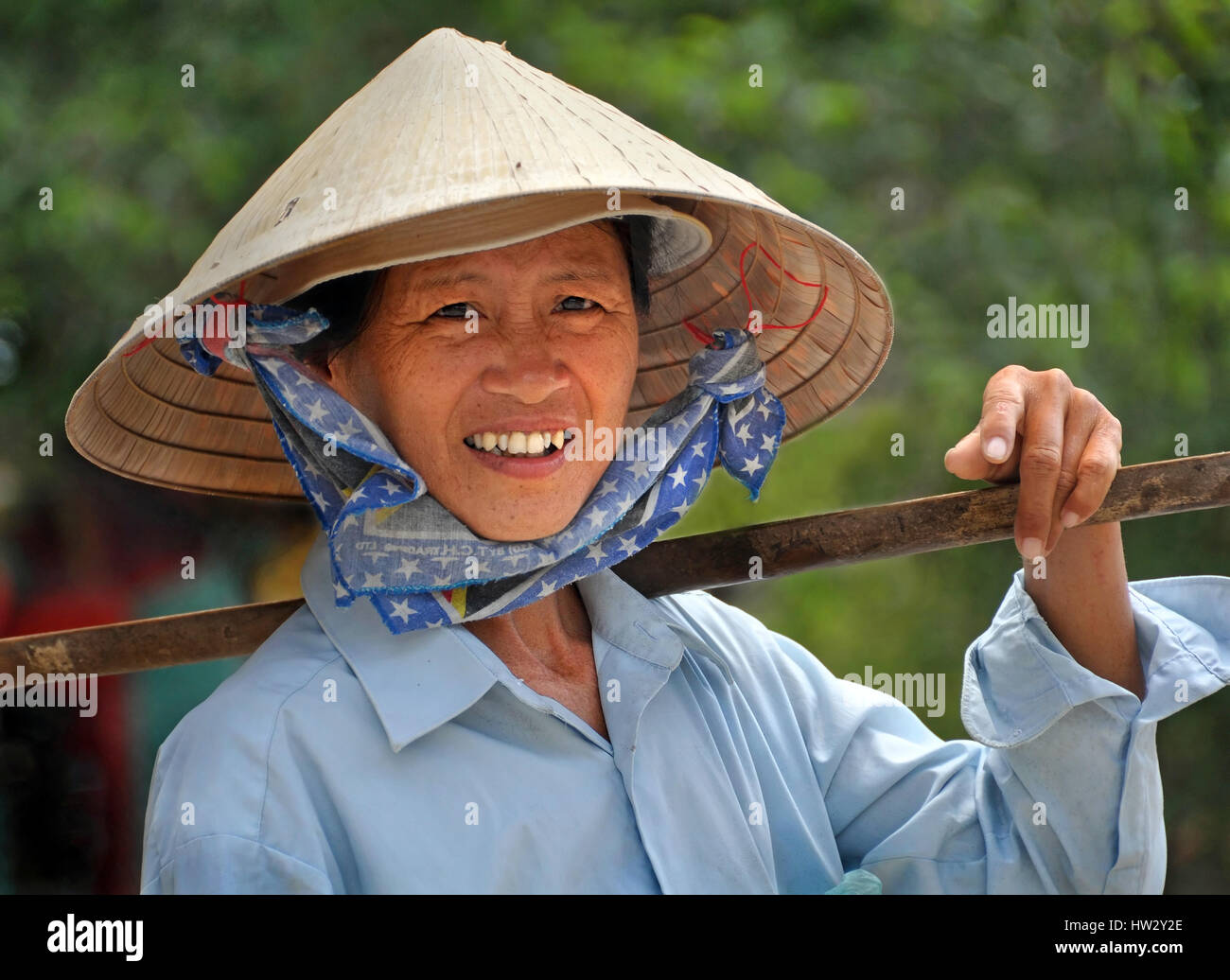 A woman in a traditional Vietnamese hat takes a break from selling fruit  and vegetables from her baskets in the streets of Saigon. Ho Chi Minh City,  V Stock Photo - Alamy