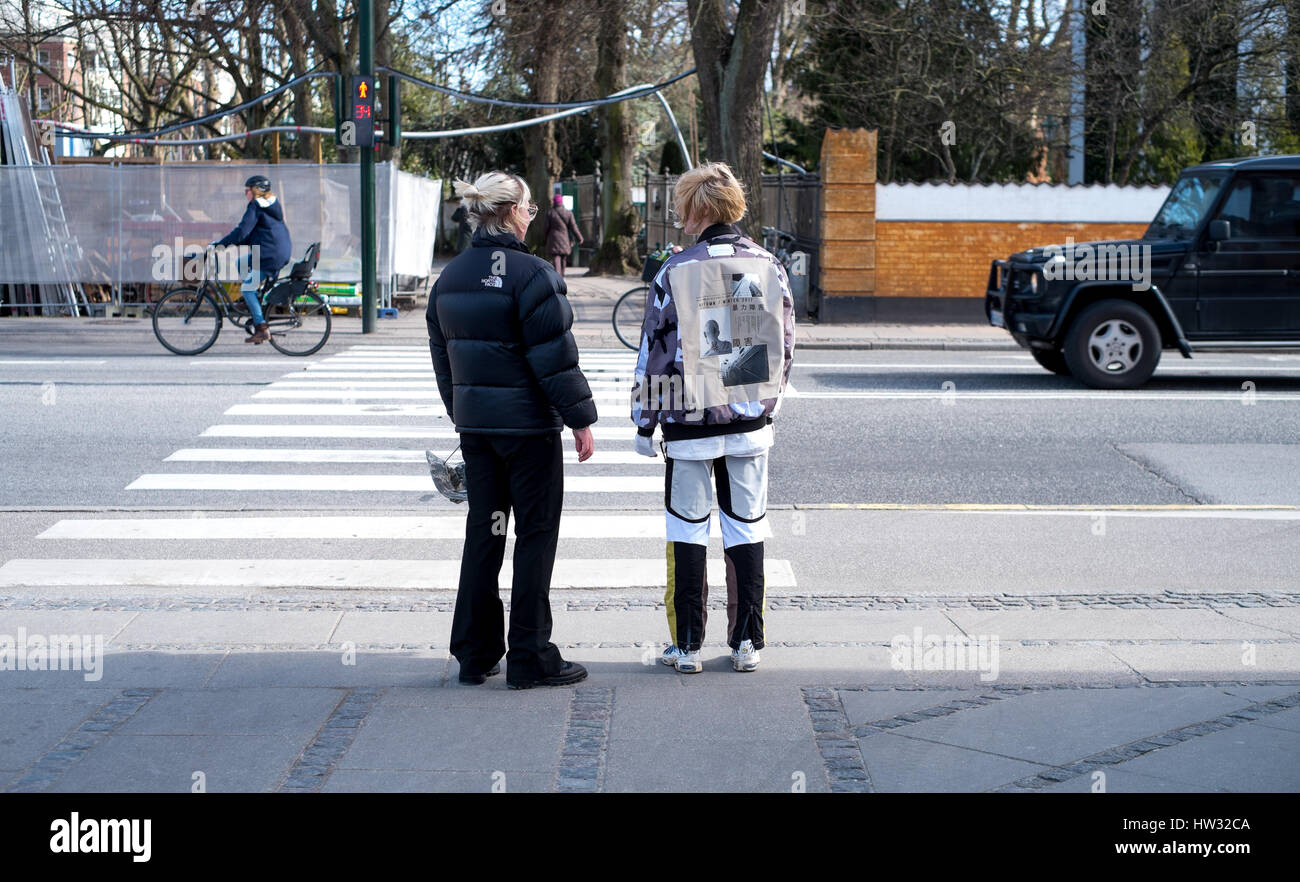 Rear view of two women (and walking advert) at Frederiksberg Rundel, Copenhagen, Denmark Stock Photo