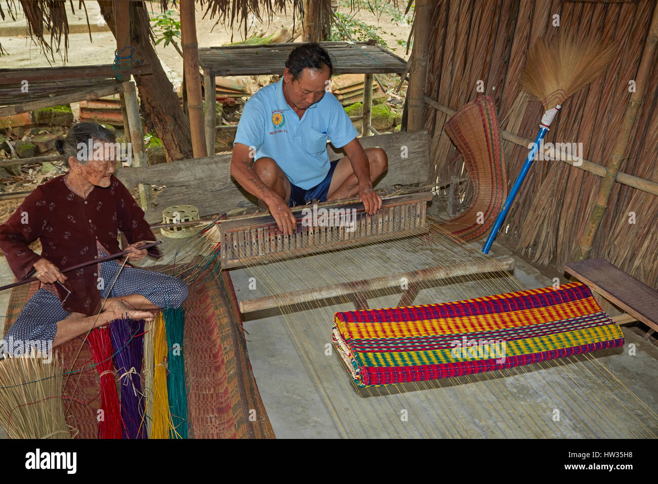 Elderly woman and man weaving sleeping mats, Cam Kim Island, Hoi An, Vietnam Stock Photo