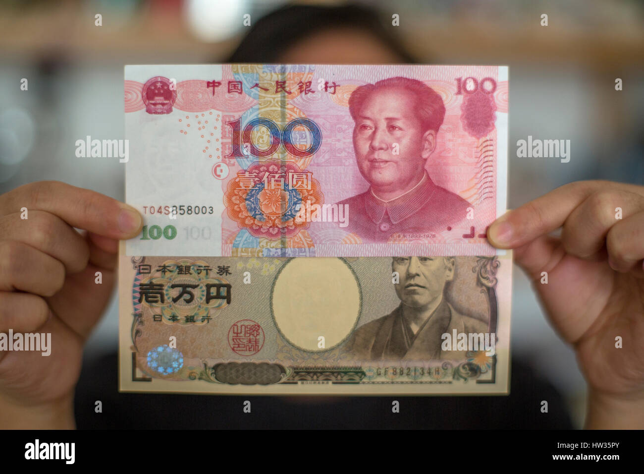 Ten Rmb A girl holds banknotes of a one-hundred RMB banknote and a ten-thousand ...