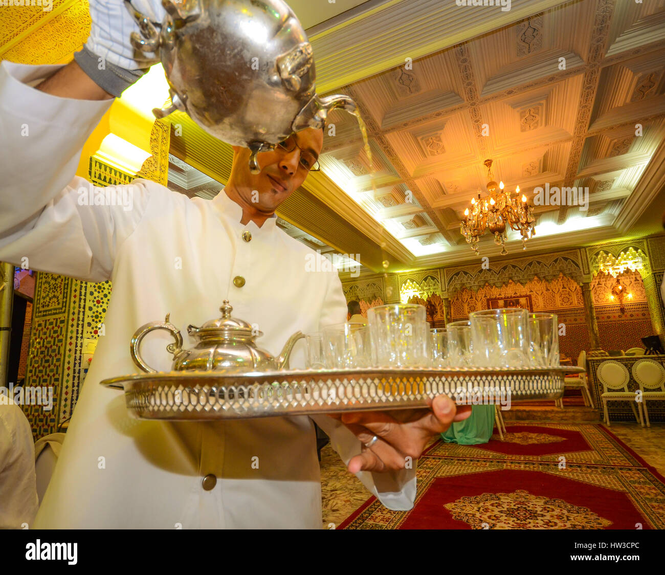 Moroccan man serving a traditional Moroccan tea a traditionally Arabic room Stock Photo
