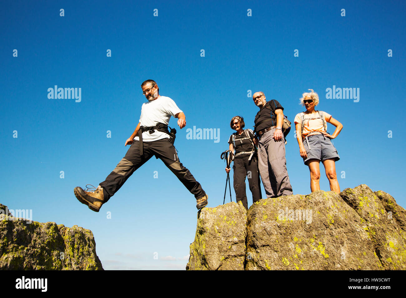 A group scrambling on Striding Edge on Helvellyn, Lake District, UK. Stock Photo