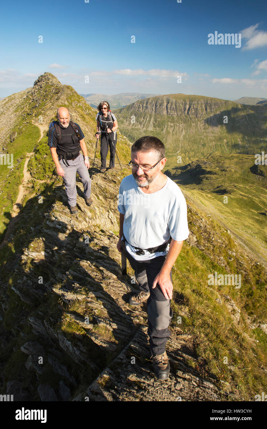 A group scrambling on Striding Edge on Helvellyn, Lake District, UK. Stock Photo