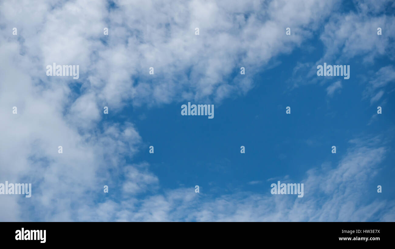 White fluffy clouds on a blue sky background Stock Photo - Alamy