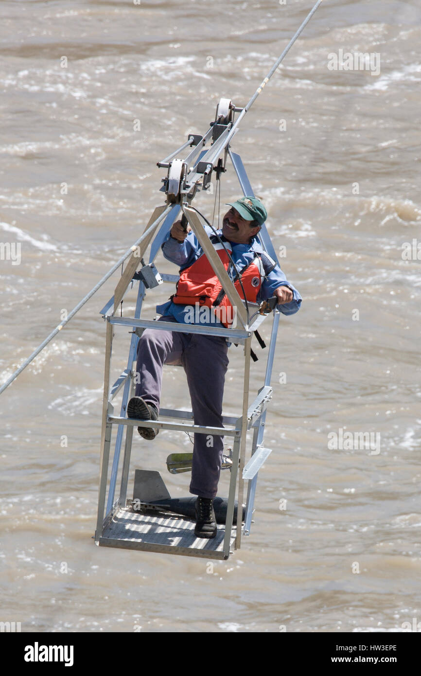 Hydrologic technician muscles his cable basket back to the starting point after taking Missouri River current measurements below Morony Dam. Stock Photo