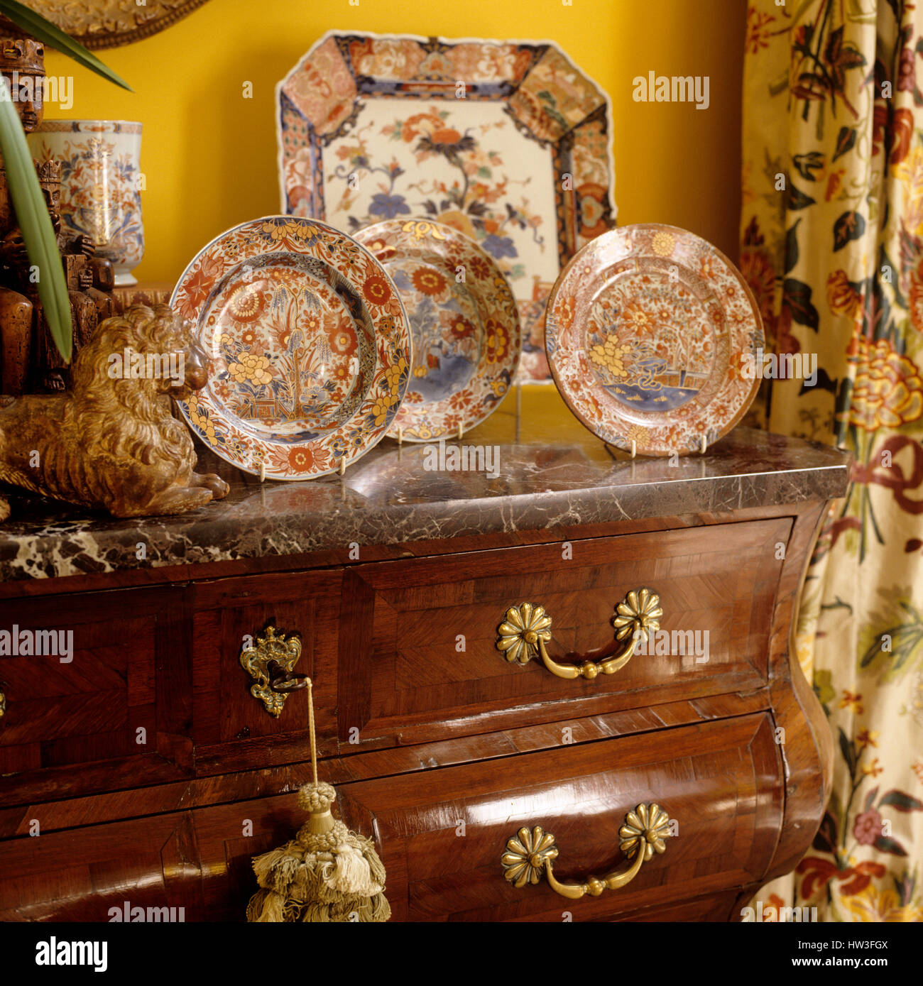 Floral patterned plates on chest of drawers. Stock Photo