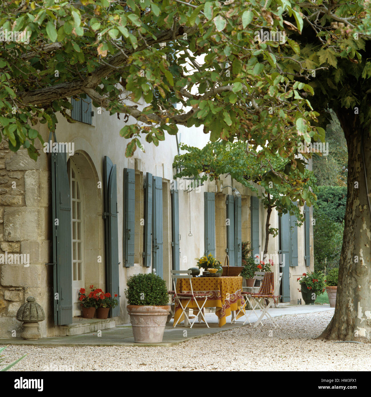 Table and chairs outside house. Stock Photo