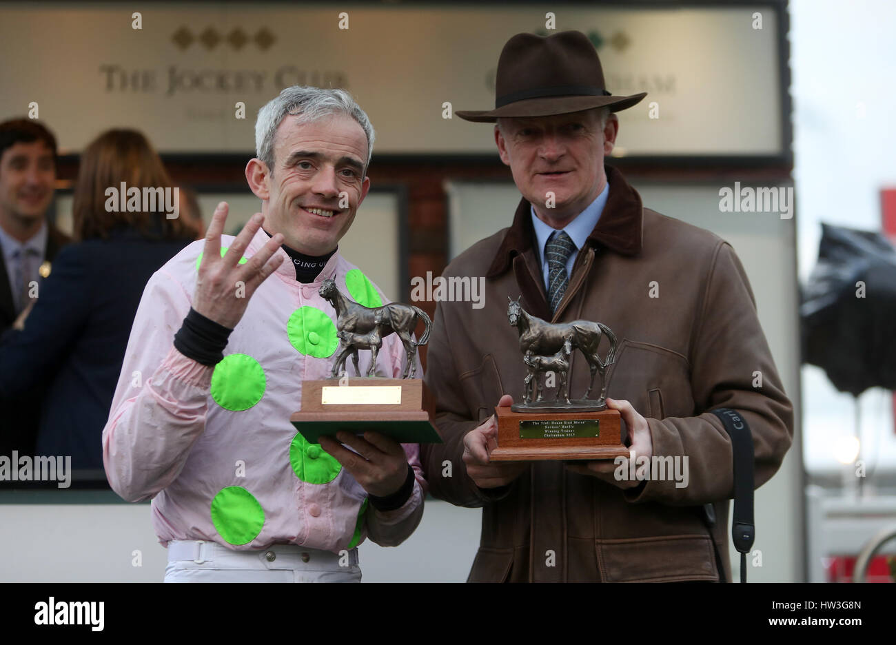 Jockey Ruby Walsh (left) and Trainer Willie Mullins (right) celebrate receiving trophies after winning the Trull House Stud Mares' Novices' Hurdle on Let's dance and achieving four wins during St Patrick's Thursday of the 2017 Cheltenham Festival at Cheltenham Racecourse. Stock Photo