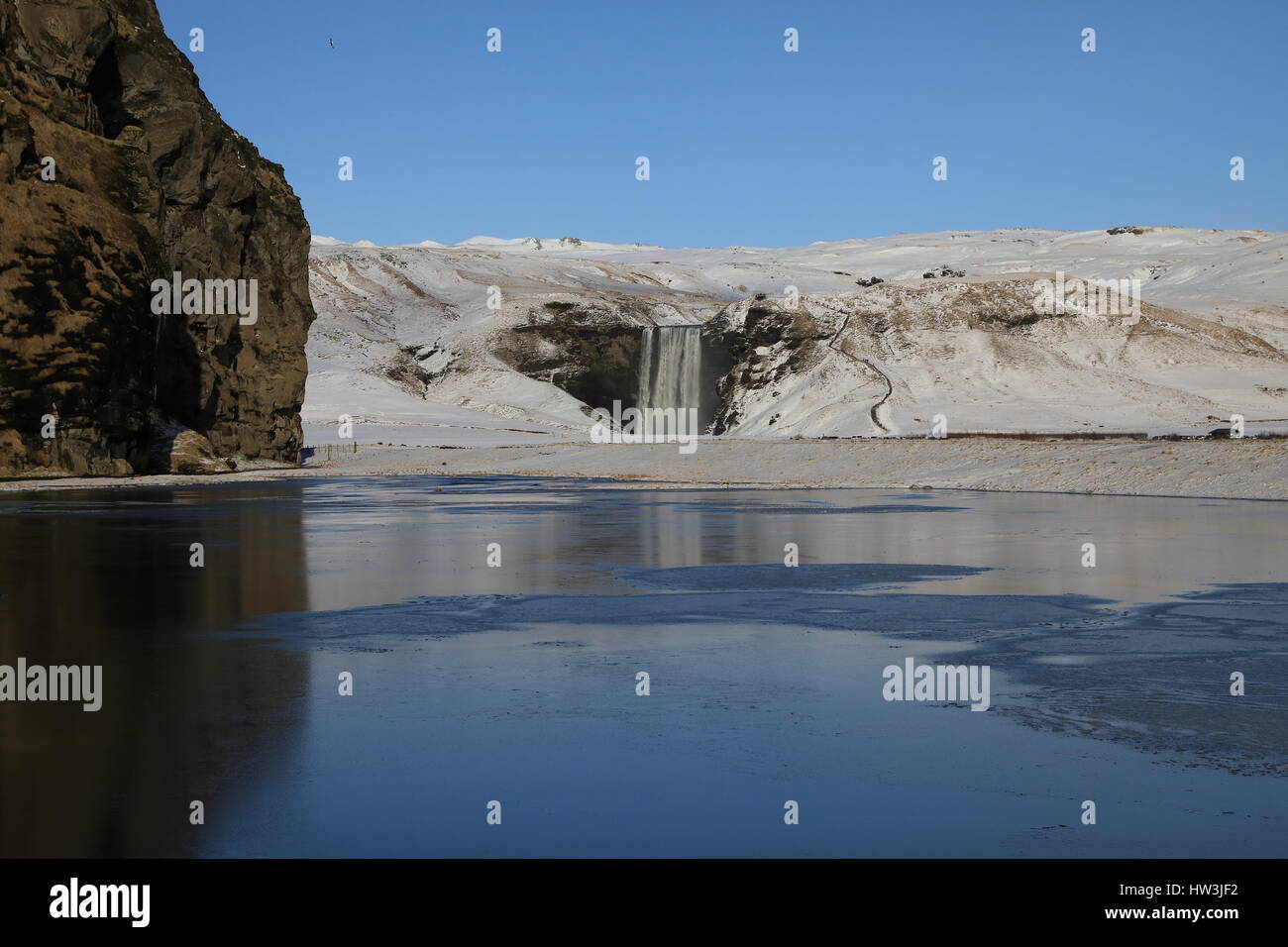 Iceland, Skogar, Skogafoss, Skogafoss waterfall surrounded by snow and ice in winter Stock Photo