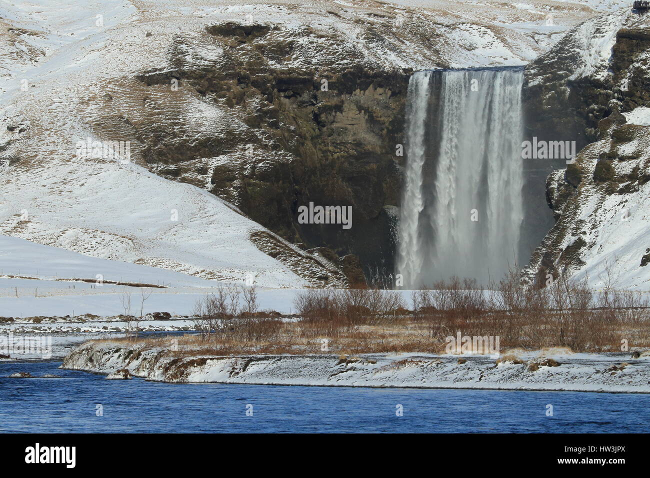 Iceland, Skogar, Skogafoss, Skogafoss waterfall surrounded by snow and ice in winter Stock Photo