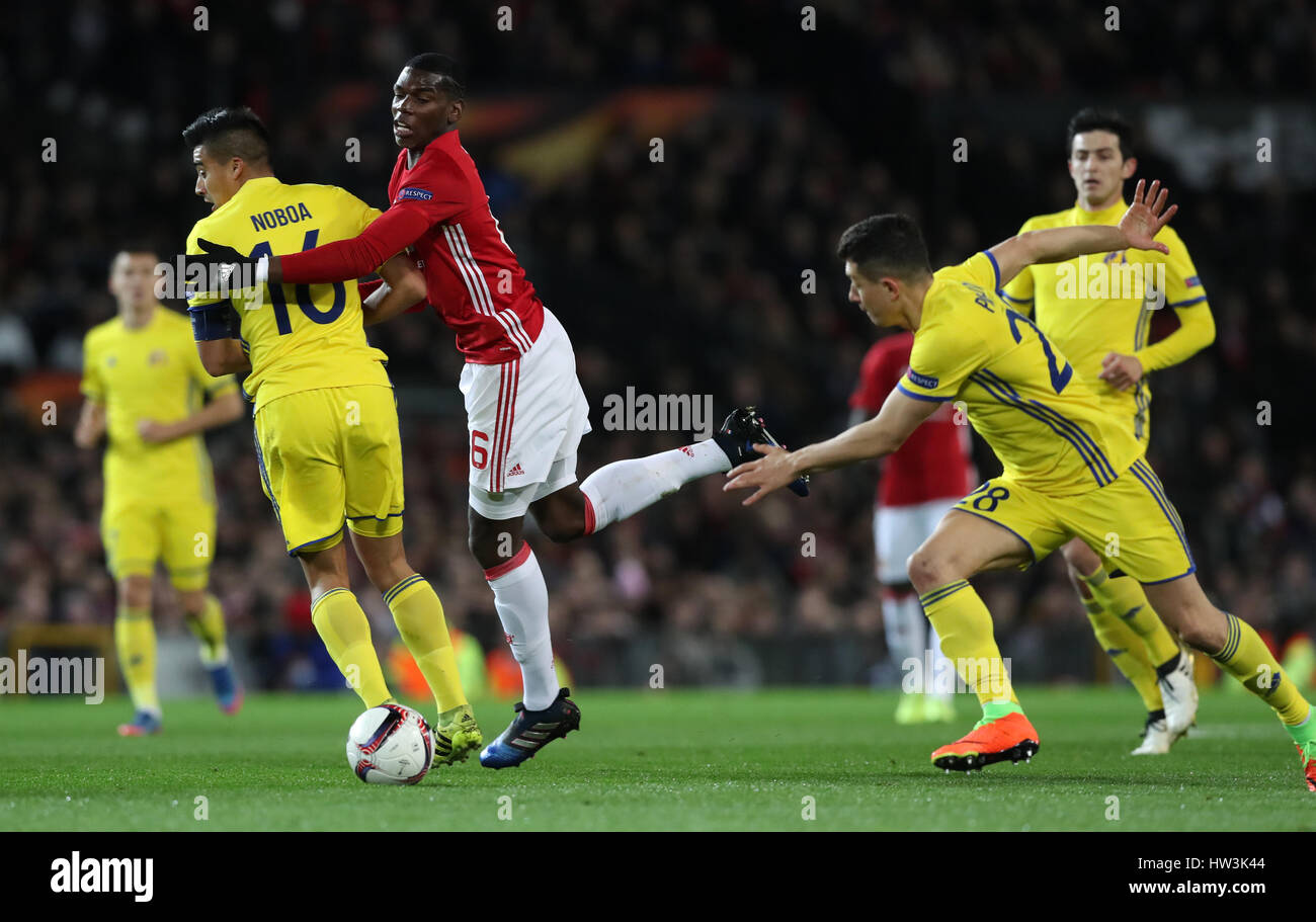 Manchester United's Paul Pogba and FC Rostov's Cristian Noboa (left) battle for the ball during the UEFA Europa League Round of Sixteen, Second Leg match at Old Trafford, Manchester. Stock Photo