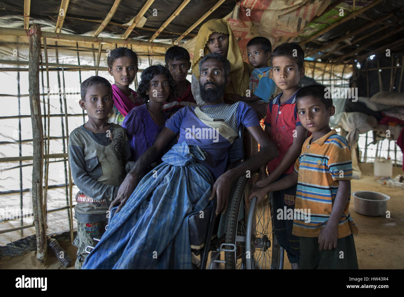 March 6, 2017 - Cox'S Bazar, Chittagong, Bangladesh - A family portrait of Mohammad Alamgir(40) who became disabled due to polio. He fled with his family from recent violence over Muslims in Myanmar; takes shelter in Kutupalong newly expanded refugee camp, Cox's Bazar, Bangladesh. About 70,000 Rohingya Muslims have fled to Bangladesh from Myanmar since October 9, 2016 after the Burmese military launched clearance operations in response to an attack on border police. There are more than 30,000 registered refugees in Bangladesh but authorities estimate that 300,000 to 500,000 unregistered Rohing Stock Photo