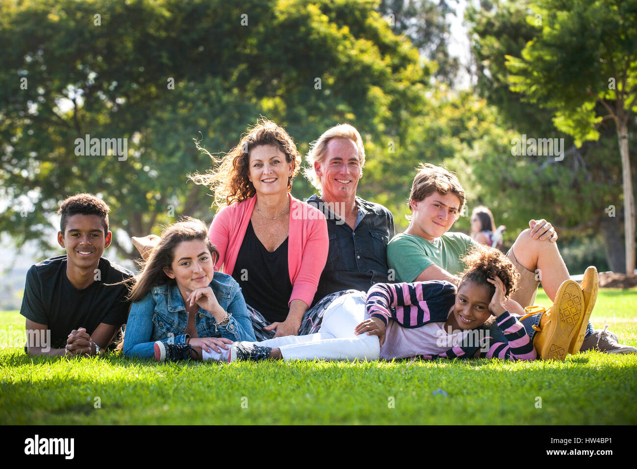 Portrait of smiling family on grass in park Stock Photo
