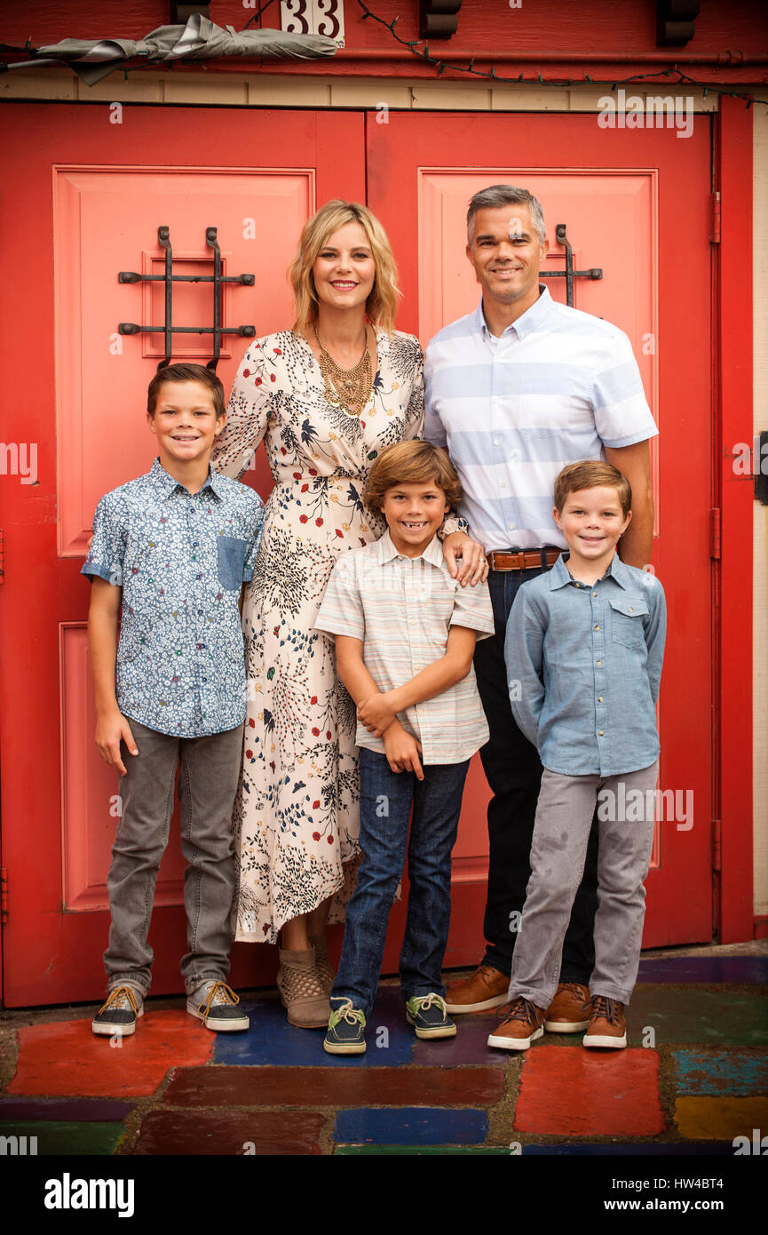 Portrait of smiling family posing near red doors Stock Photo - Alamy