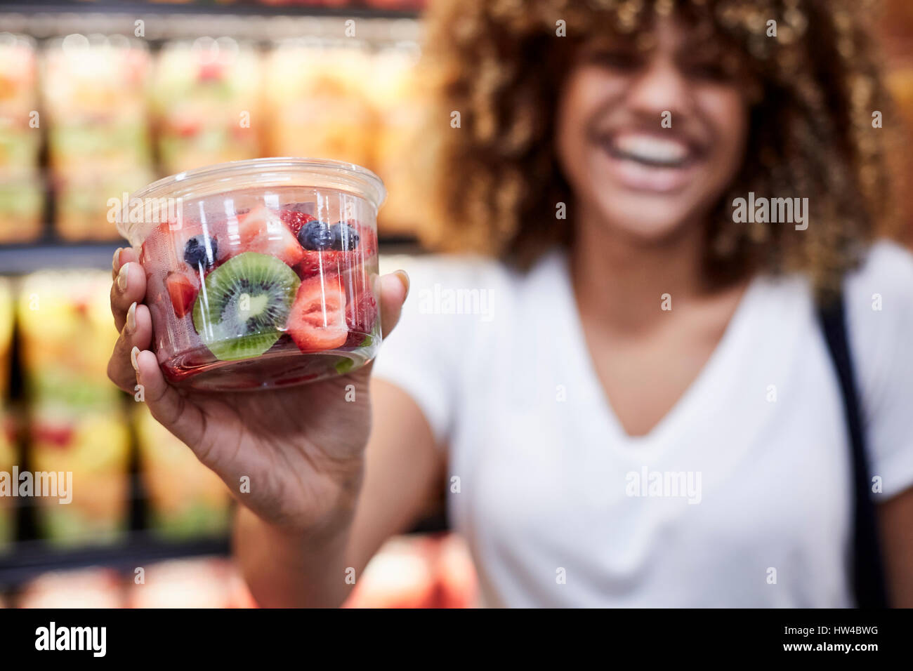 Black woman cup of fruit salad in grocery store Stock Photo