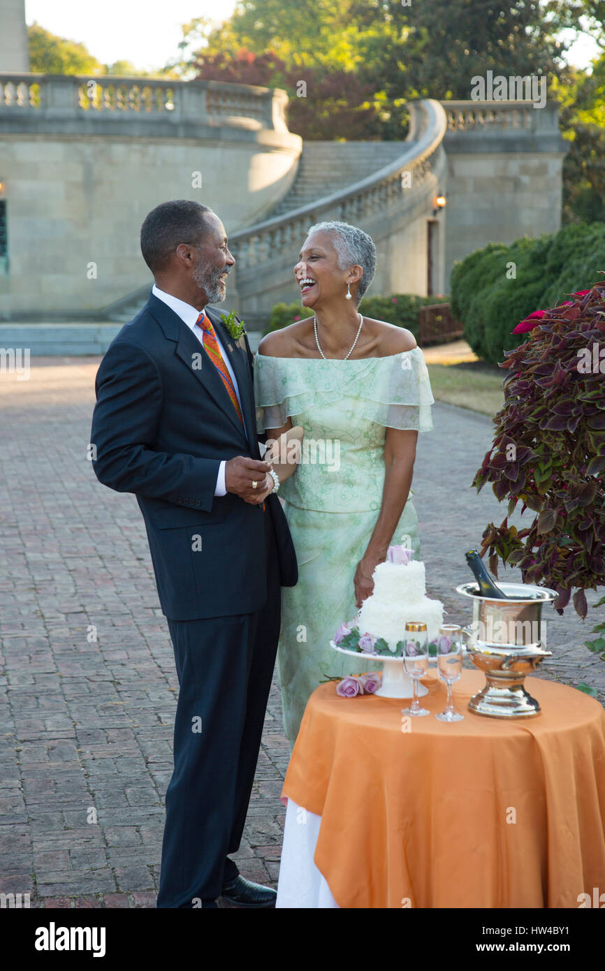 Black couple laughing near wedding cake Stock Photo