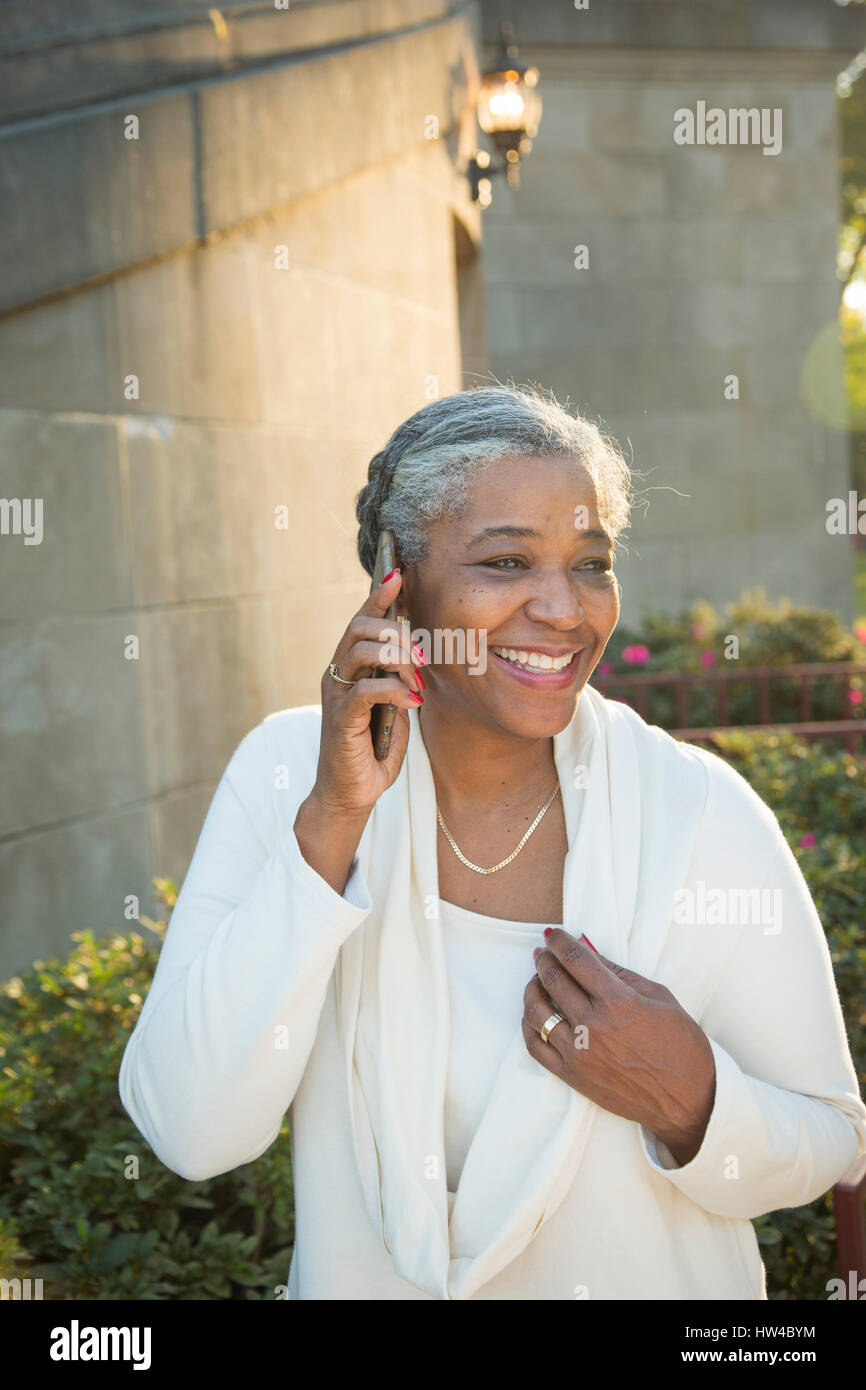 Black woman talking on cell phone near stone staircase Stock Photo