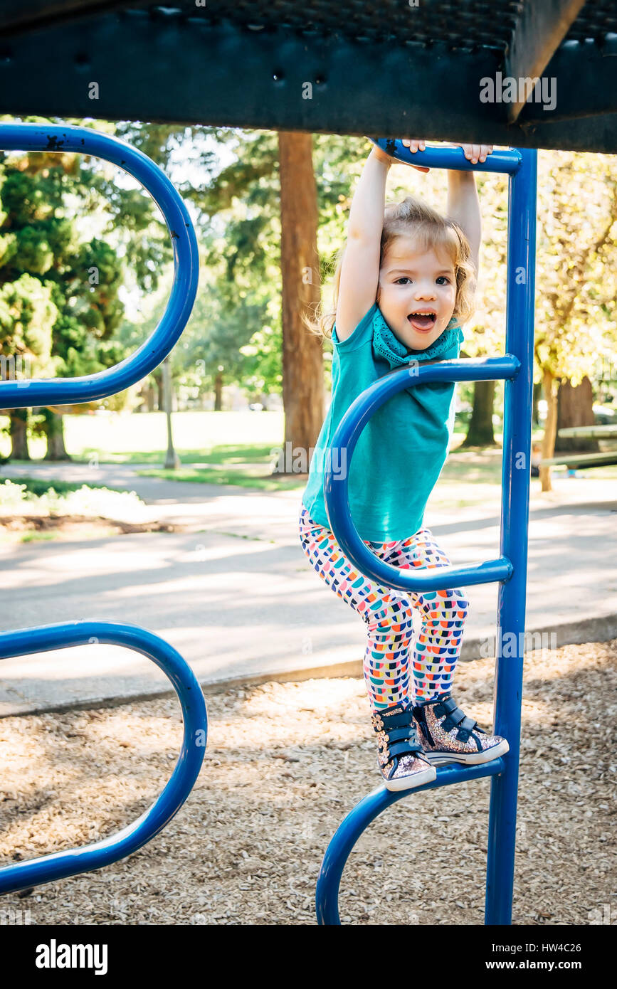 Caucasian girl climbing on playground structure Stock Photo