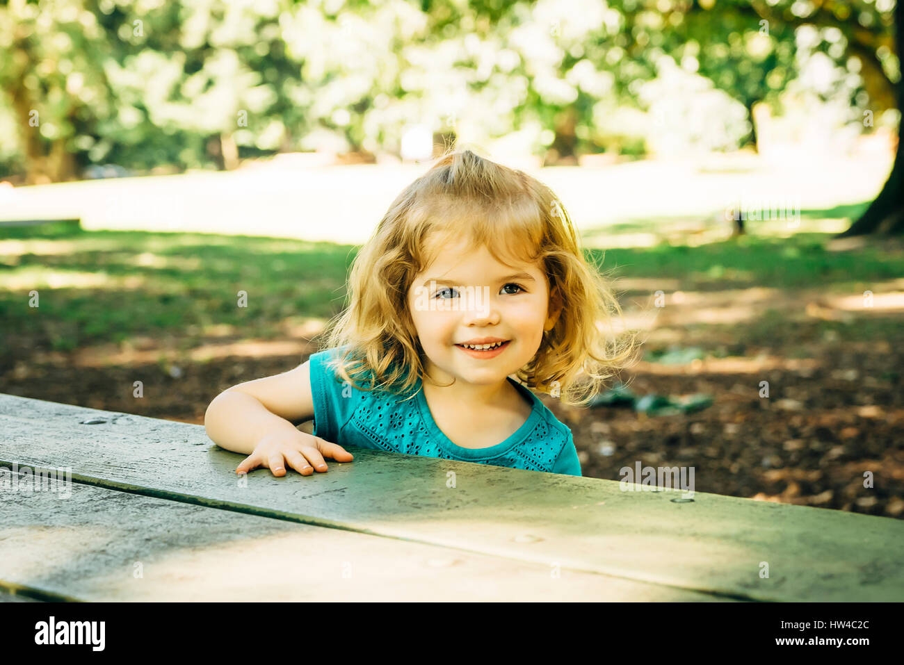 Portrait of Caucasian preschool girl at picnic table Stock Photo