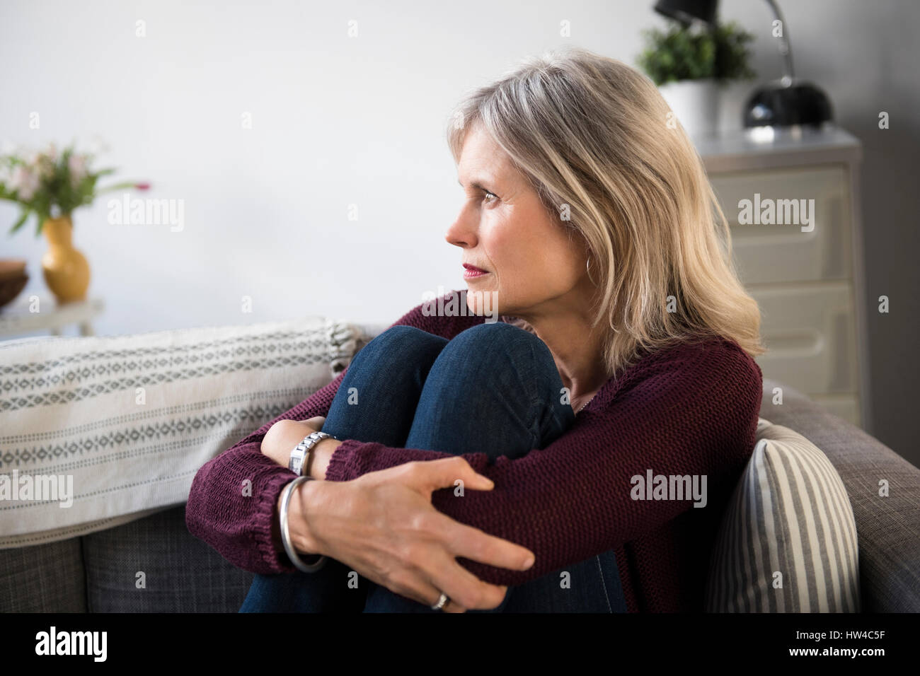 Worrying Caucasian woman hugging legs Stock Photo