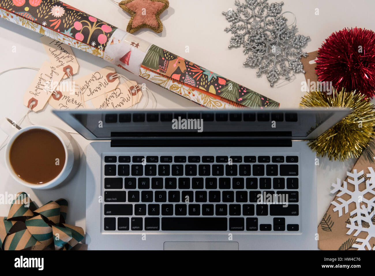 Laptop, coffee, wrapping paper and Christmas ornaments Stock Photo