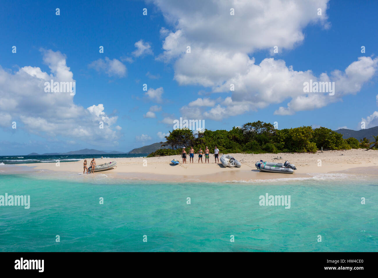 Tourists standing on tropical beach Stock Photo