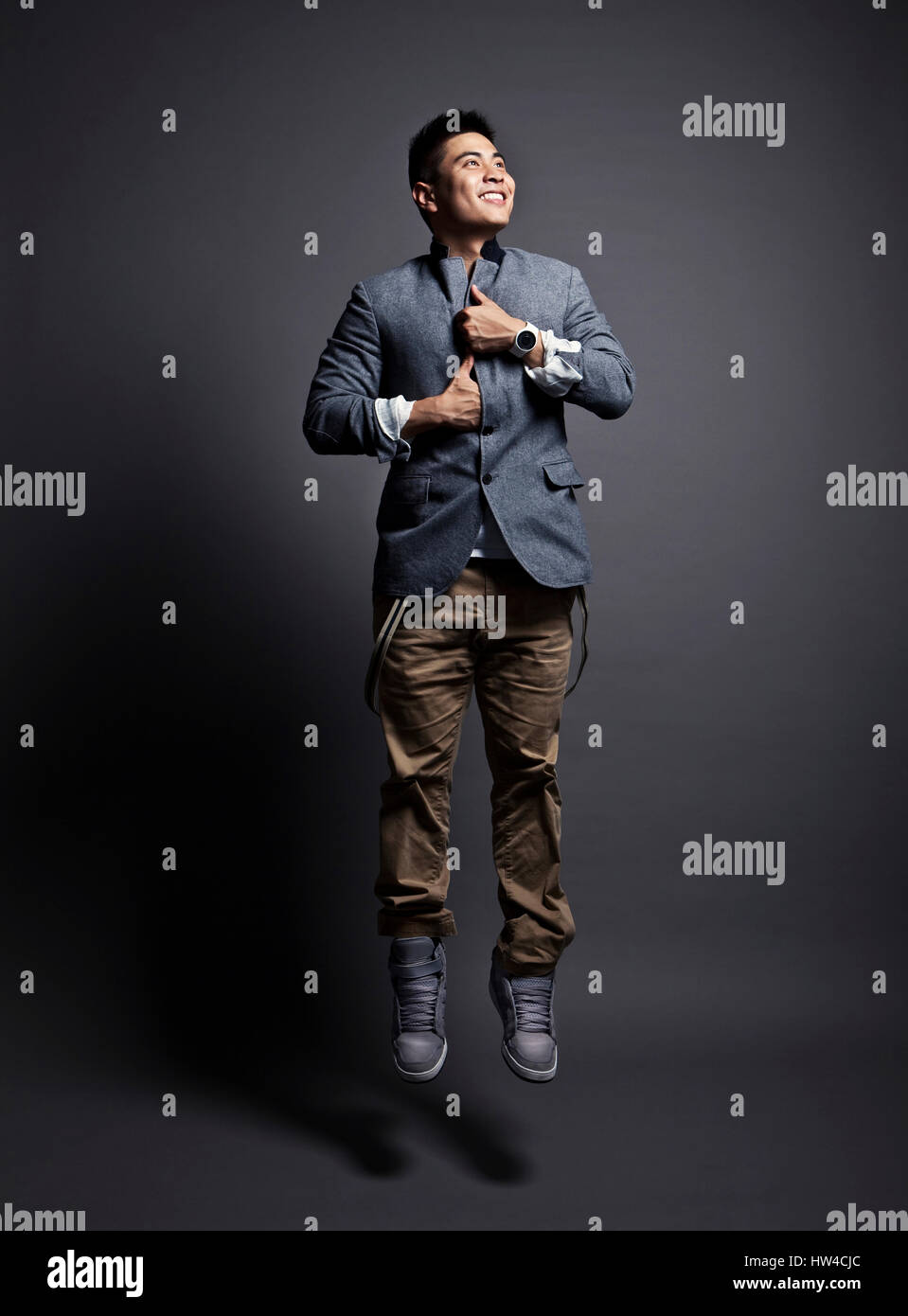 Chinese man wearing jacket and jumping Stock Photo