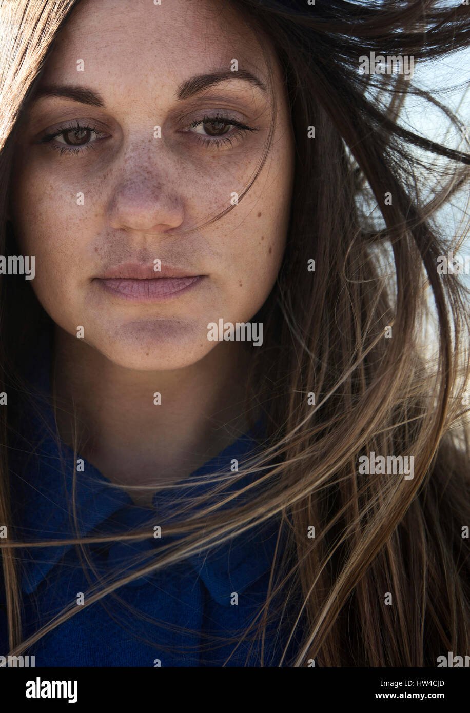 Wind blowing hair of Caucasian woman with freckles Stock Photo