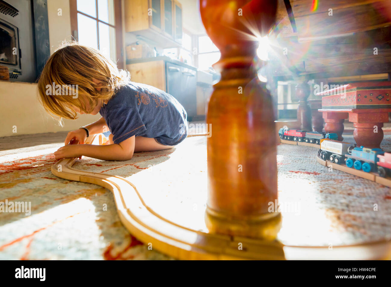 Caucasian boy playing with toy race track on floor Stock Photo