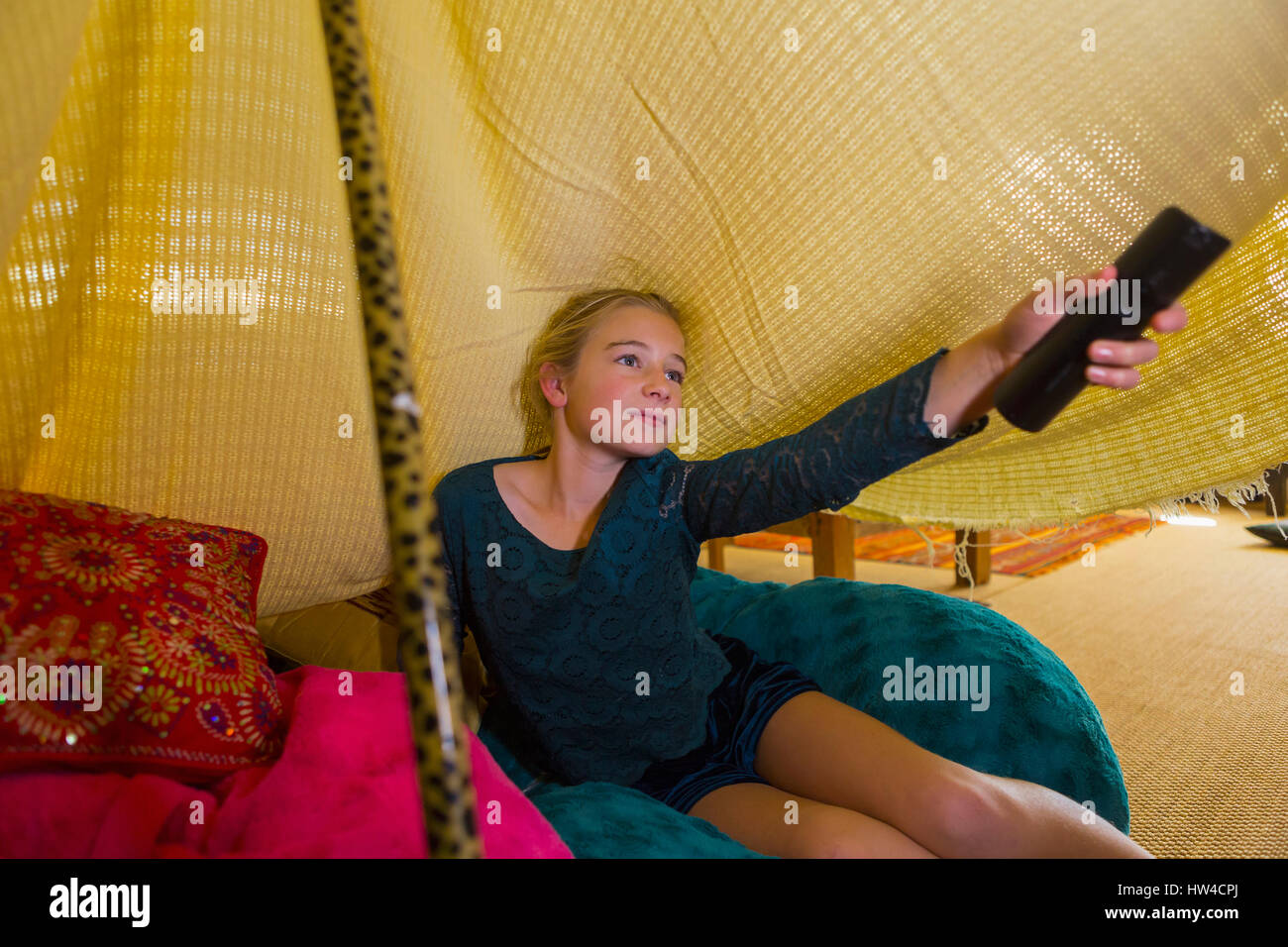 Caucasian girl using remote control in blanket fort Stock Photo