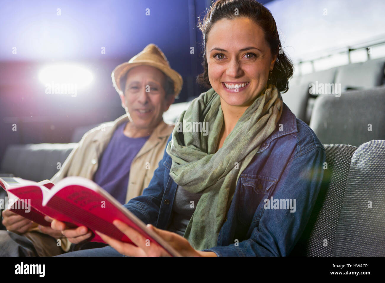 Portrait of Caucasian actors sitting in audience with scripts in