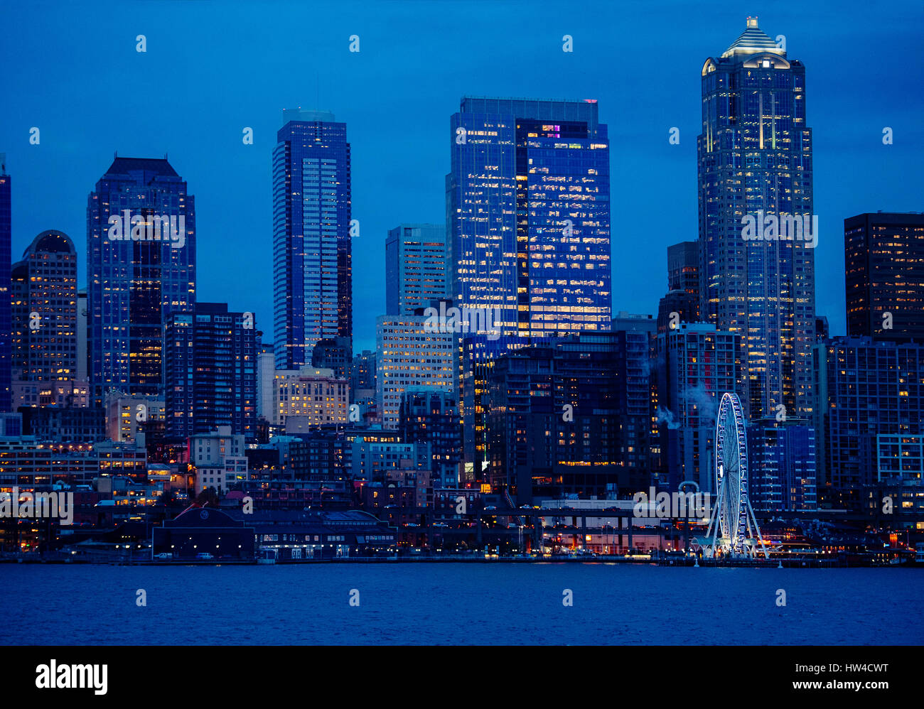 Illuminated city skyline at waterfront Stock Photo