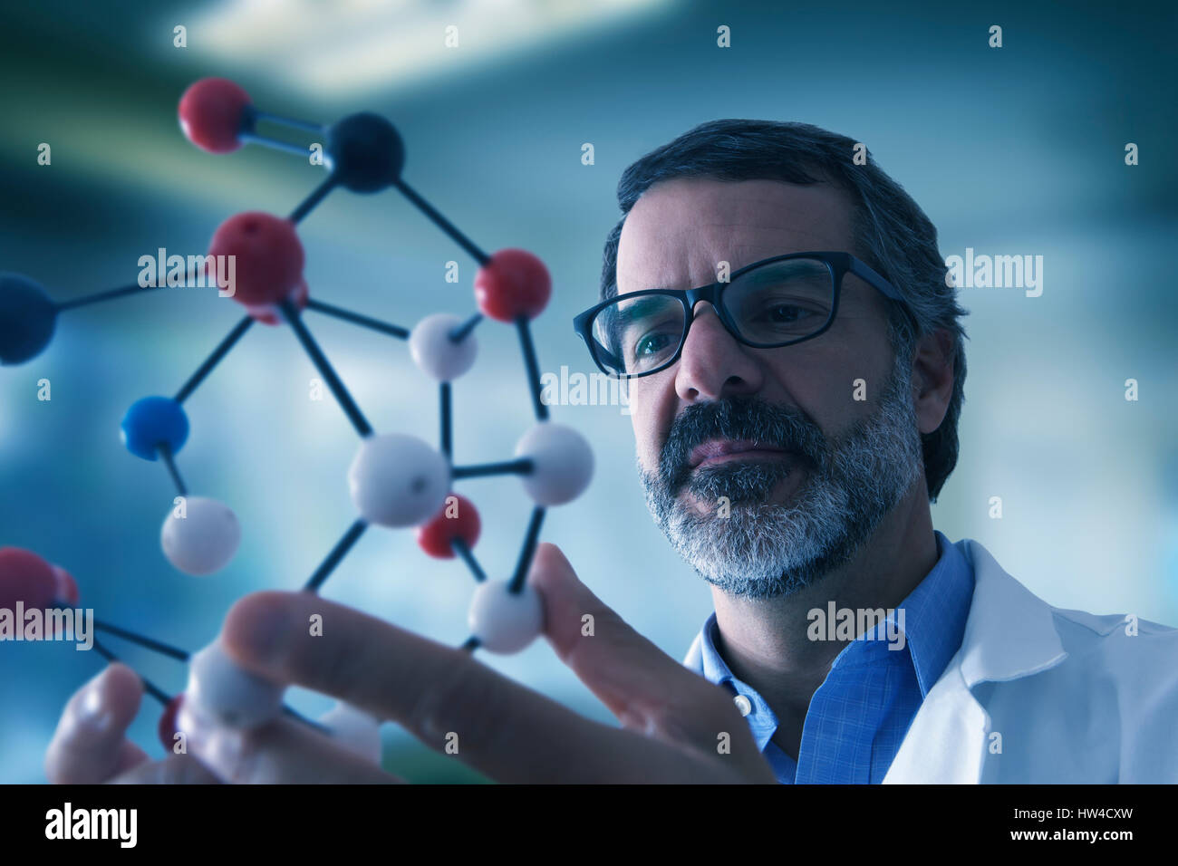 Hispanic scientist examining molecule model Stock Photo