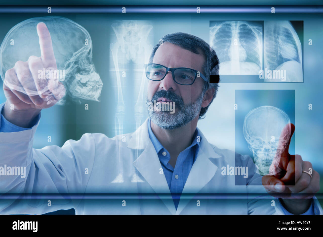 Hispanic doctor examining x-rays on virtual screen Stock Photo