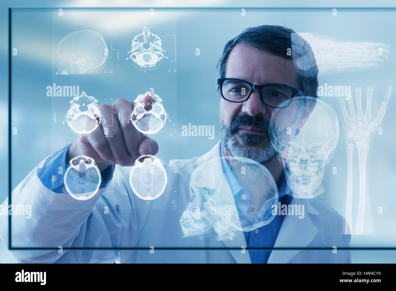 Hispanic doctor examining x-rays on virtual screen Stock Photo