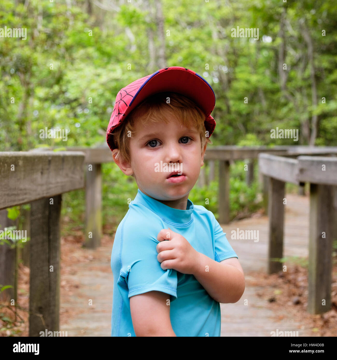 Caucasian boy scratching shoulder in park Stock Photo