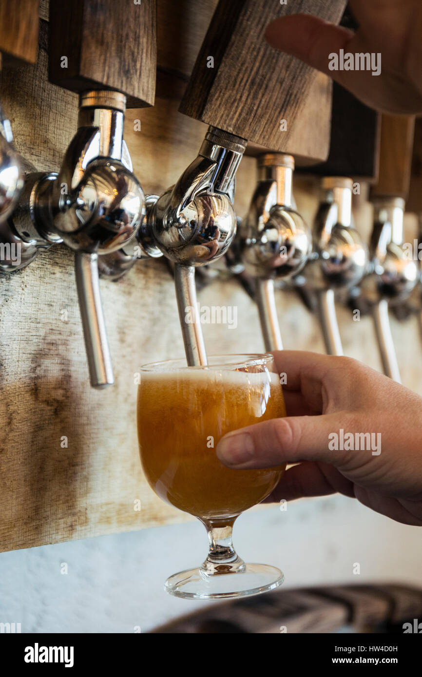 Hand of Caucasian man pouring beer from tap Stock Photo