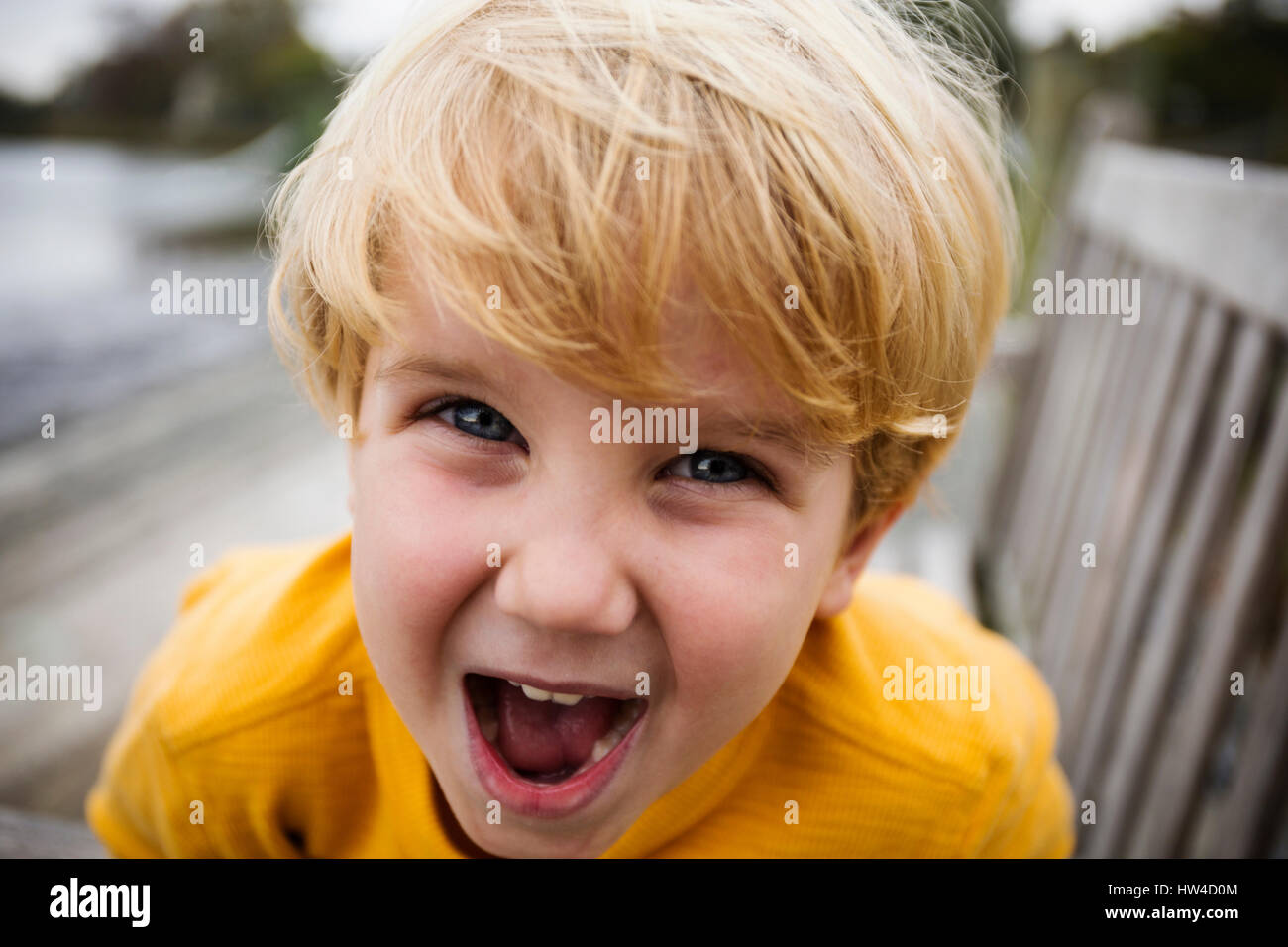 Playful Caucasian boy yelling on bench Stock Photo