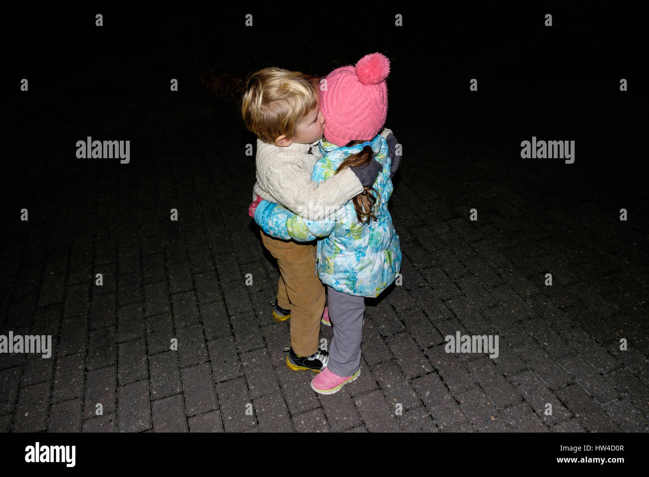 Boy ad girl hugging outdoors at night Stock Photo