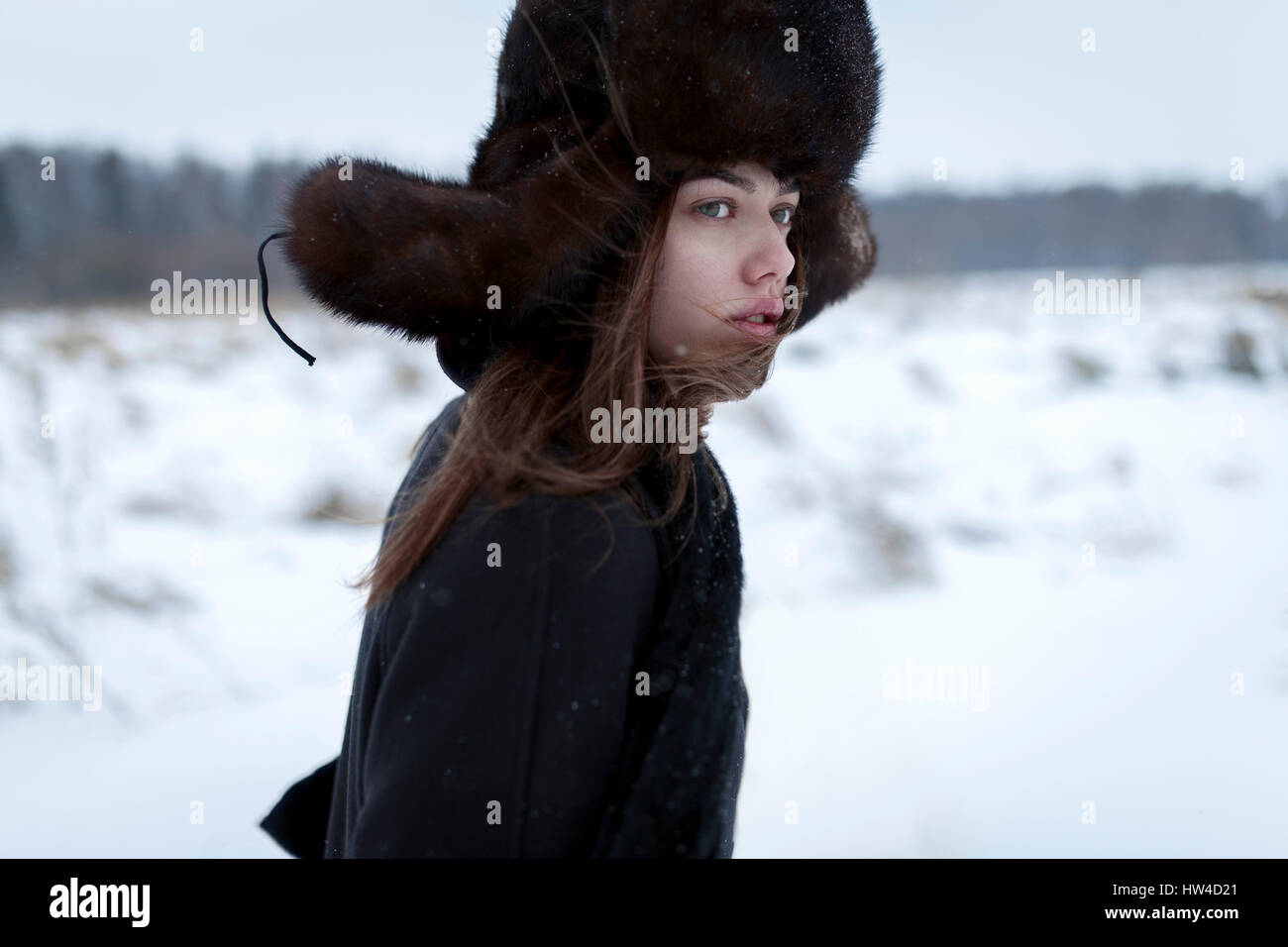 Serious Caucasian woman wearing fur hat and coat in winter Stock Photo