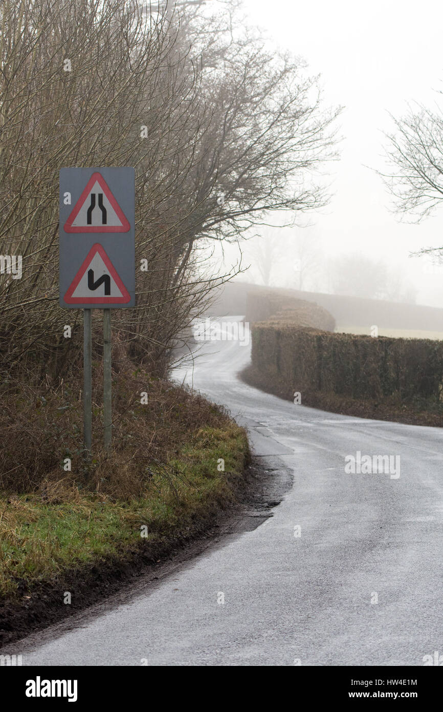 Road narrows and double bends, first to the left, on a road in Wales with light winter fog. Near the Glanusk Estate in Brecon National Park Stock Photo