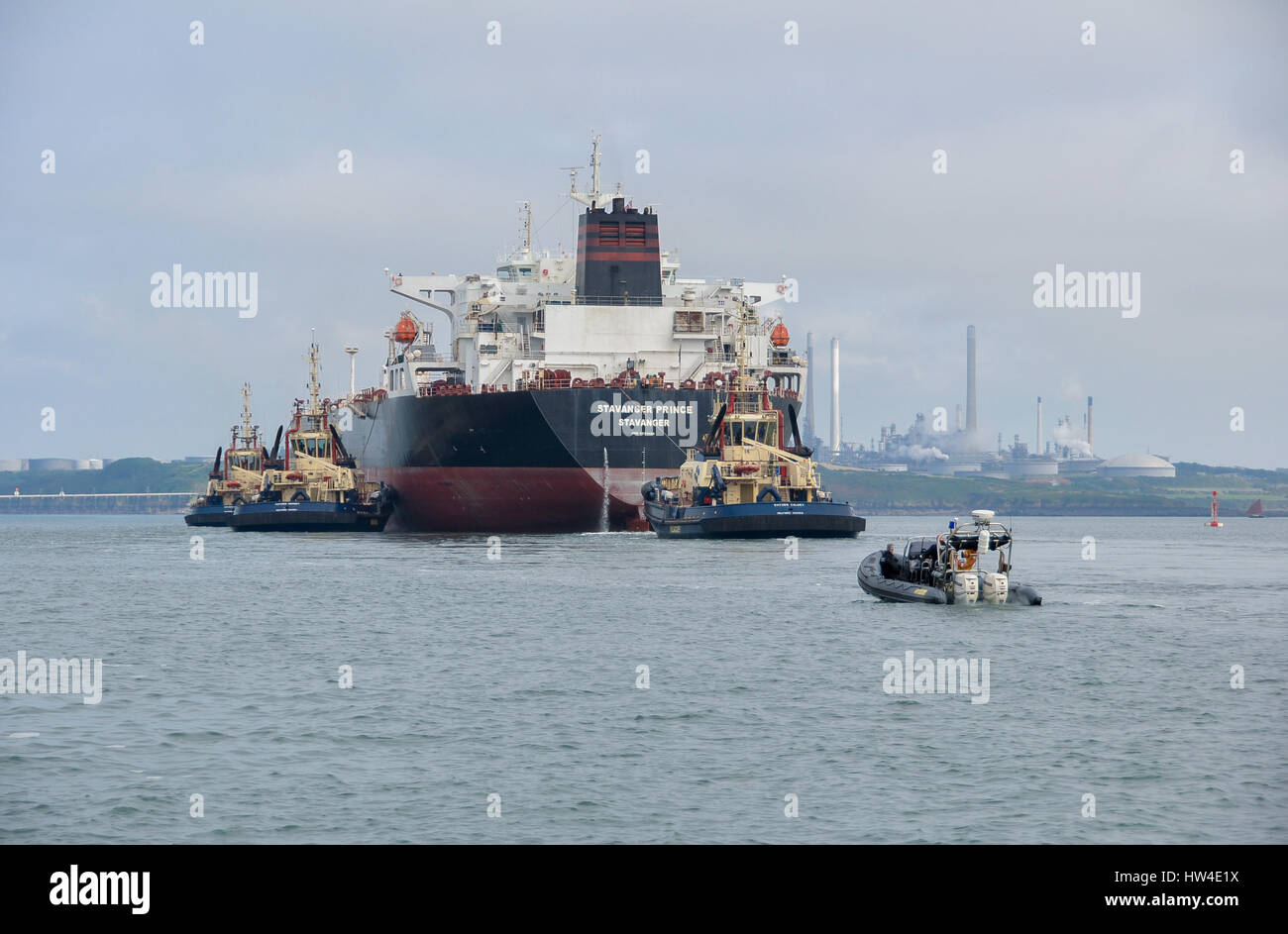 Super tanker Stavanger Prince being assisted into Milford Haven by three tugs and being followed by the Police rib. Stock Photo