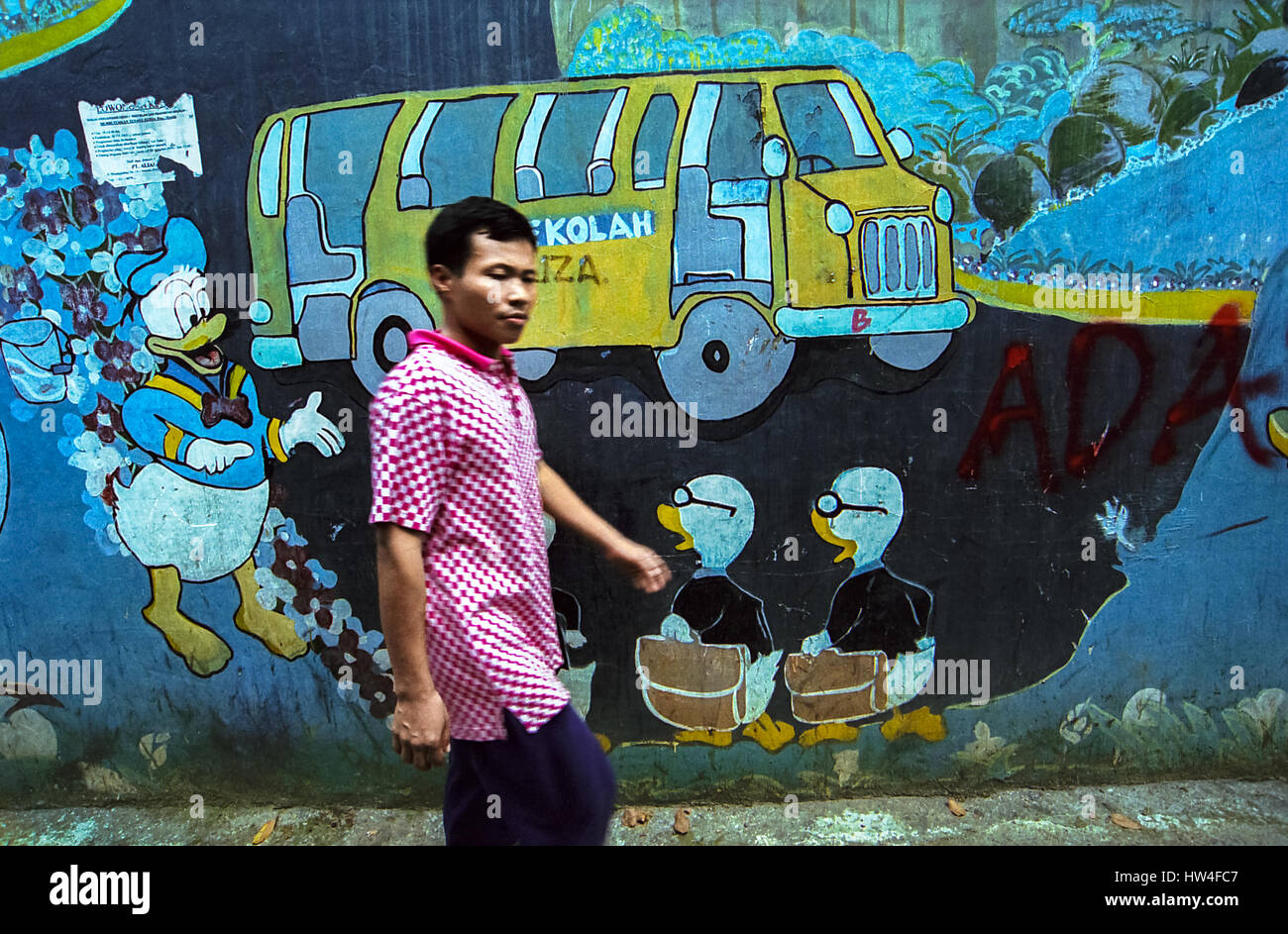 A pedestrian walking on an alley decorated with cartoon characters wall  painting in Palmerah area, Jakarta, Indonesia Stock Photo - Alamy