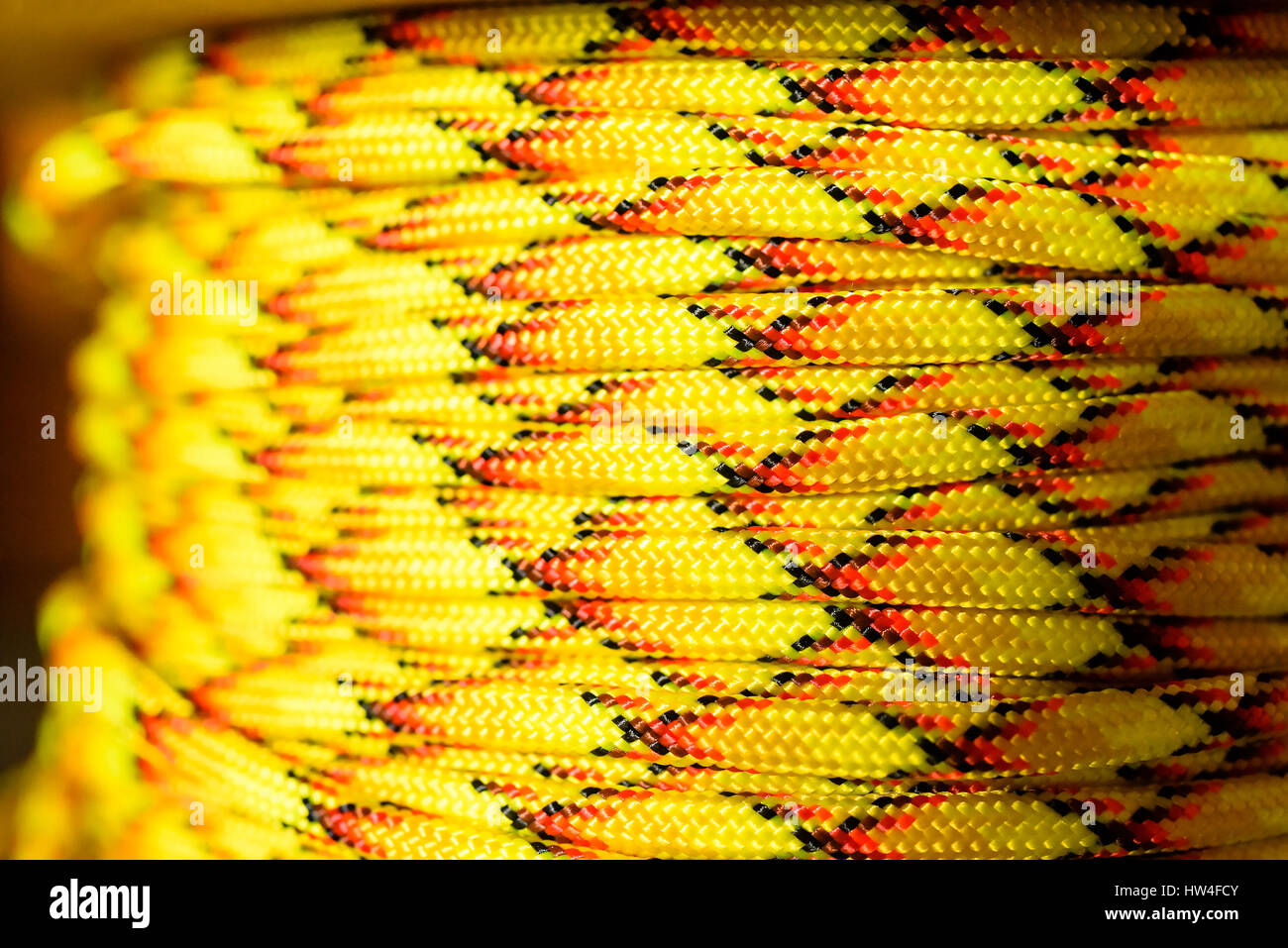 Parachute cord or paracord on spool. Yellow, red and black nylon