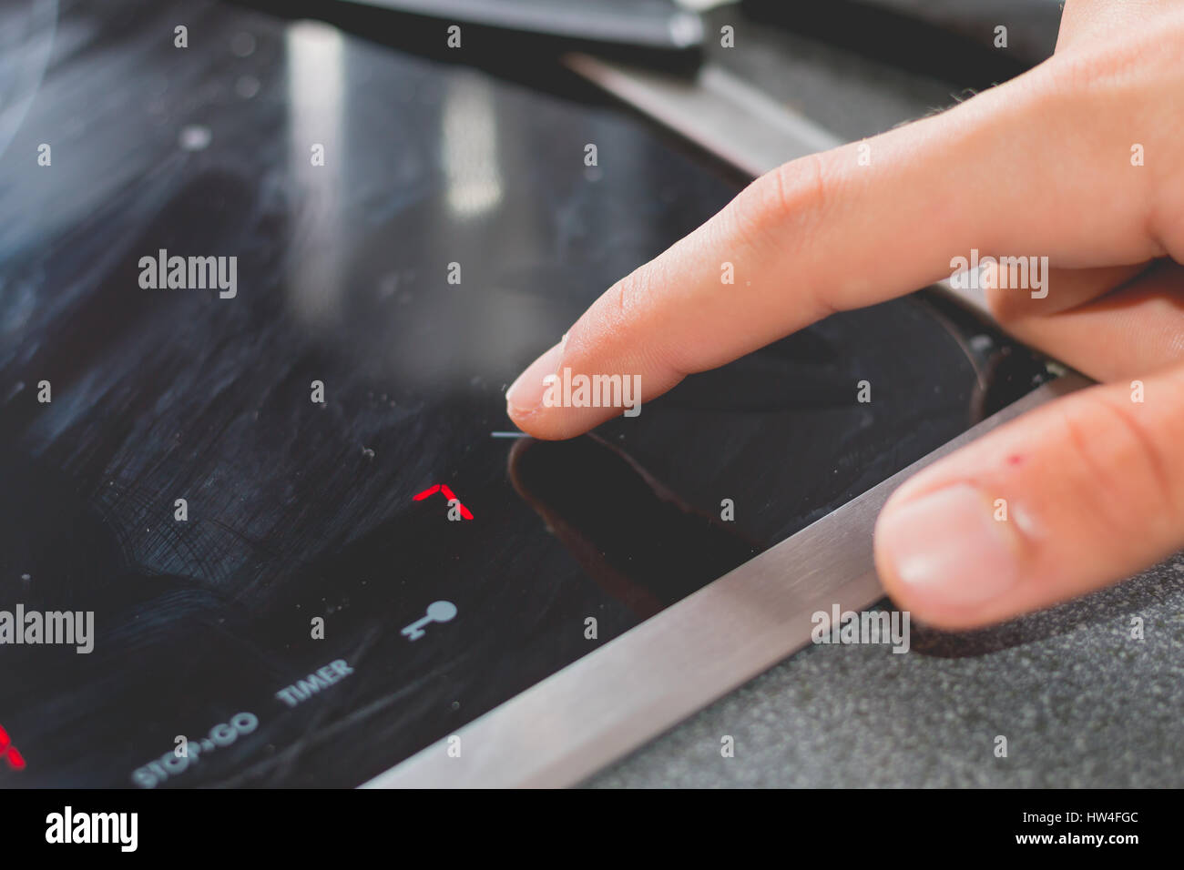 Cook who starts Induction Cooktops in a kitchen Stock Photo Alamy