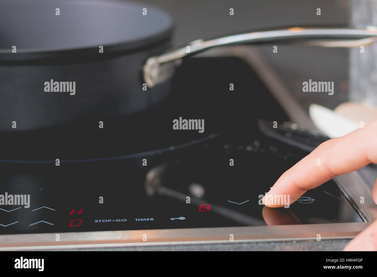 Cook who starts Induction Cooktops in a kitchen Stock Photo Alamy