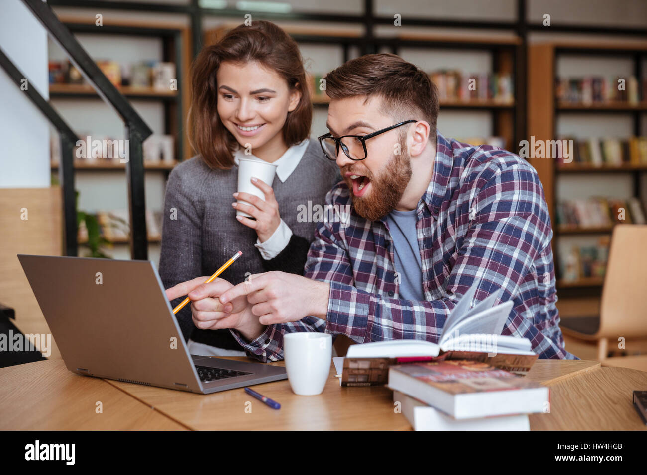 Two young university students studying in library Stock Photo - Alamy