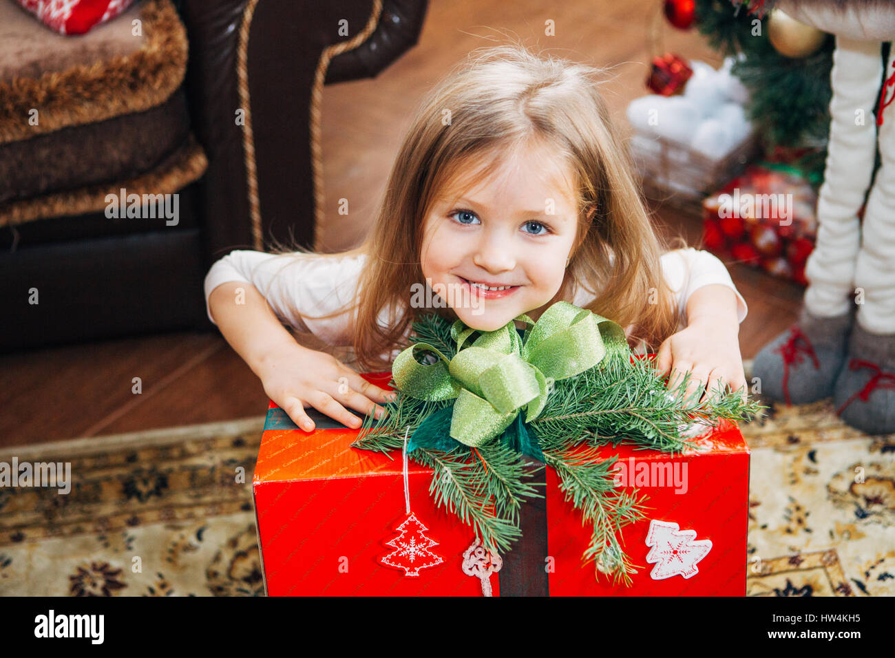 little cute girl holding a Christmas gift Stock Photo - Alamy